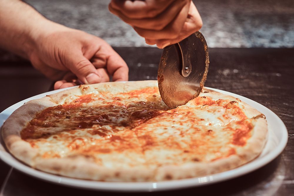 chef-is-cutting-traditional-margarita-pizza-for-customers-with-special-knife.jpg