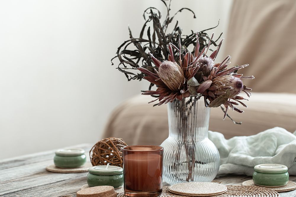 cozy-home-composition-with-candles-and-protea-bouquet.jpg